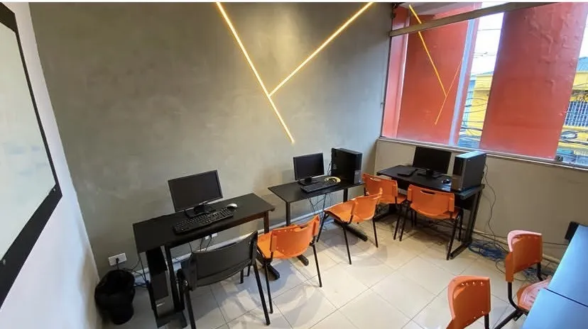 Laboratório de informática da unidade com computadores e luzes de LED na parede