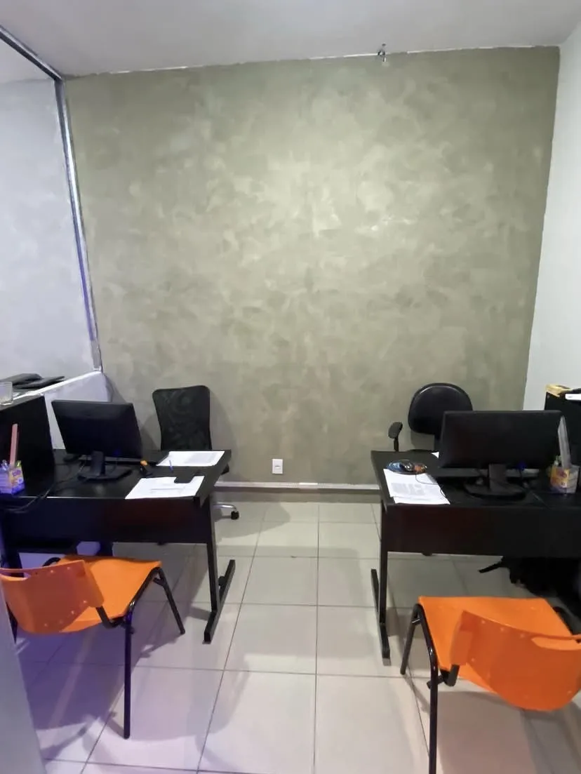 Sala de estudo da unidade com dois computadores e cadeiras laranja
