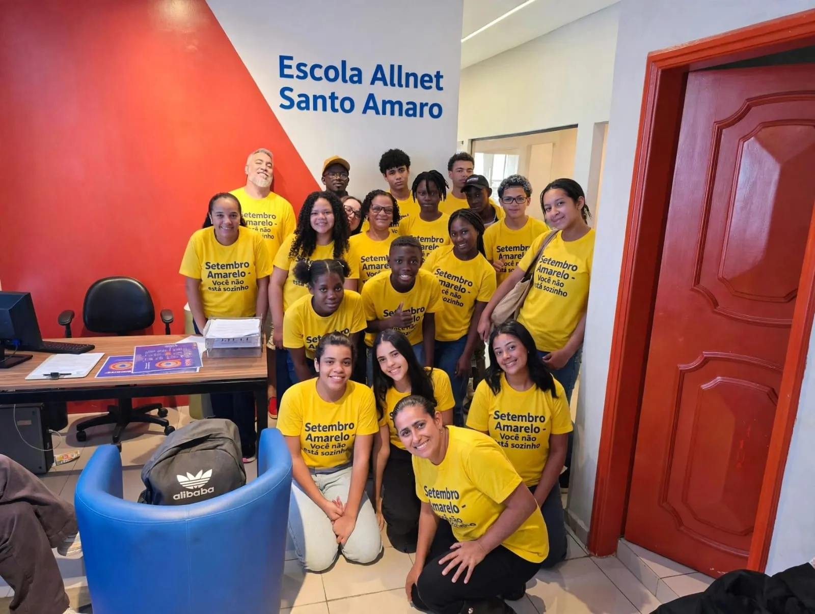 Alunos, professores e equipe da All Net Santo Amaro de camiseta amarela do Setembro Amarelo, na recepção da escola